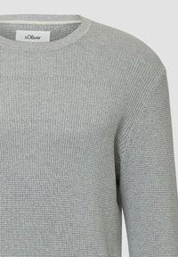 Jasnoszary sweter z teksturowanej tkaniny i okrągłym dekoltem. Projekt zawiera poziome prążkowane wzory oraz subtelny metek z logo.