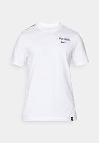 Hvid bomulds T-shirt med korte ærmer, der har "PARIS" og Nike-logoet i marineblå på brystet. Accentfarver i rød på skuldrene.