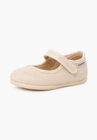 Chaussure Mary Jane beige pour tout-petit en tissu texturé, fermeture à scratch, semelle souple et petite étiquette de marque sur le côté.