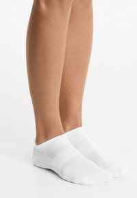 White ankle socks featuring a textured knit design, contrasting ribbed sections, and seamless toe. Soft fabric with a snug fit.