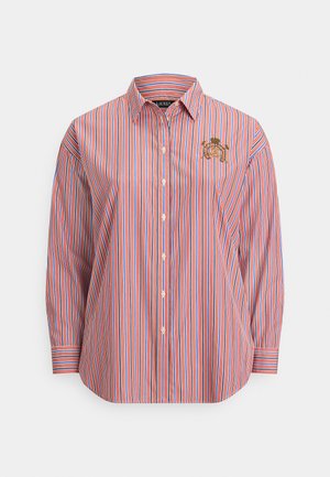 Ilgas rankovėmis marškiniai su sagomis, raudonai, baltai ir mėlynai vertikaliomis juostelėmis bei auksine siuvinėta emblema ant krūtinės.