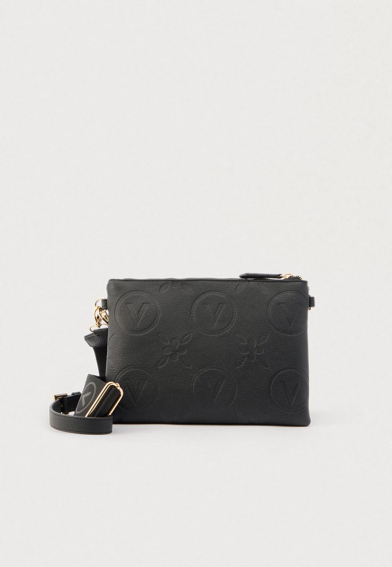 Musta suorakaiteen muotoinen nahkainen olkalaukku, jossa kohokuvioidut ympyränmuotoiset logot ja kukkakuviot, säädettävä hihna kullanvärisillä metalliosilla.