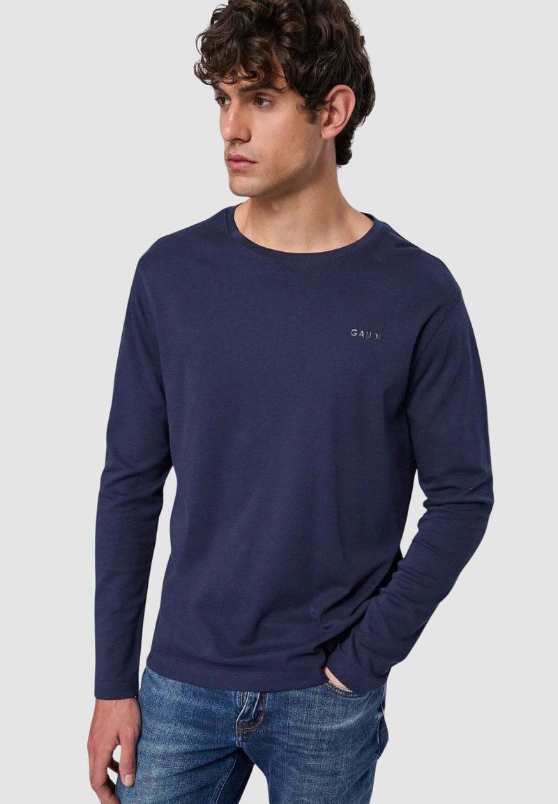 T-shirt a maniche lunghe blu navy in morbido tessuto con scollatura rotonda e dettaglio del logo. Abbinato a jeans in denim azzurro.