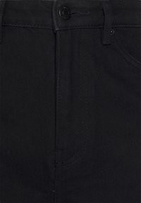 Jeans de ganga pretos com uma textura suave, design clássico de cinco bolsos e fecho frontal com botão. Detalhes costurados ao longo das costuras.