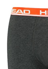 Graue Baumwollboxershorts mit elastischem Bund, ausgestattet mit einem orange-weißen "HEAD"-Logo. Glatte Textur, taillierte Passform.