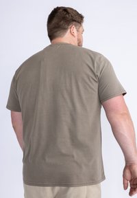 Olivově zelené tričko s krátkým rukávem vyrobené z měkké bavlny, s kulatým výstřihem, rovním lemem a minimem švů pro čistý design.