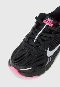 Scarpa da corsa nera Nike con tomaia in rete, dettagli rosa, elementi riflettenti e suola in gomma. Presenta lacci e un collare imbottito per il comfort.