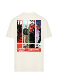 Cream cotton t-shirt featuring a graphic print on the back, with multicolored panels and text, depicting scenes from a vintage TV series.