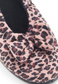 Luipaardprint pantoffel in zacht roze stof, met een strikaccent, ronde vorm en zwarte zool. De binnenkant is zwart en plush.