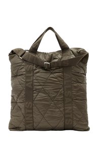 Zelená prošívaná taška přes rameno s polstrovanou texturou, dvojitými horními uchy a odnímatelným ramenním popruhem, na kterém je výrazně vytištěný název značky.