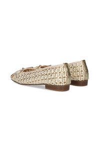 Bailarinas beige con un diseño trenzado, acentos metálicos y un bajo tacón de madera, que presentan un acabado texturizado y una puntera redonda.