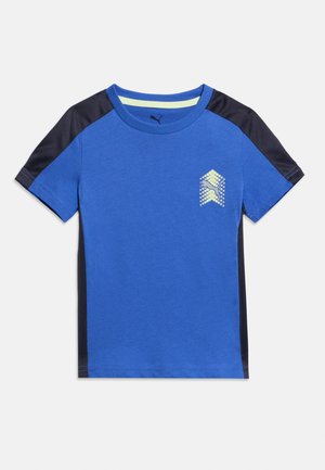 Blå T-skjorte med korte ermer, svarte skulder- og sidepaneler, rund hals og en liten lys gul prikket logo på venstre bryst.