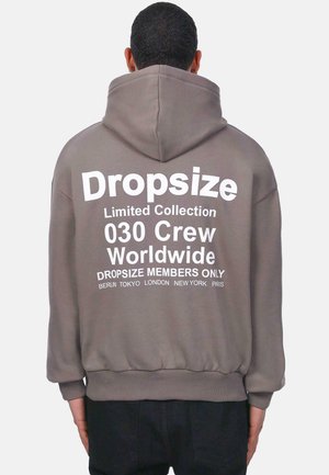 Grau Hoodie mit einem großen weißen Grafik auf dem Rücken. Der Text umfasst "Dropsize Limited Collection" und Städtenamen. Verfügt über eine Kapuze mit Kordelzug.