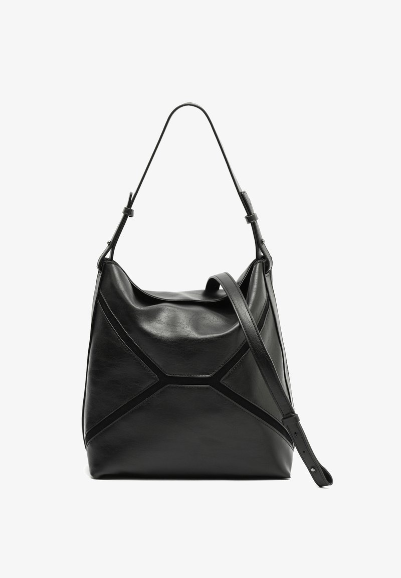 Czarna skórzana torba na ramię z pojedynczą górną rączką, geometrycznym wzorem przeszyć i regulowanym paskiem na ramię na białym tle.