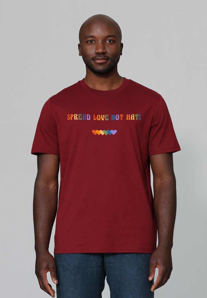 Bordeaux katoenen T-shirt met meerkleurige tekst "SPREAD LOVE NOT HATE" boven een rij kleurrijke harten. Korte mouwen en ronde halslijn.