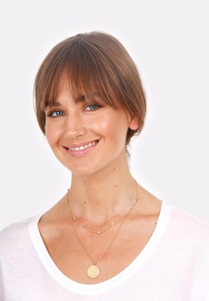 Collana a strati in oro con pendente rotondo texturizzato e piccole perline, abbinata a una camicia bianca. Superficie liscia e lucida, design chic.