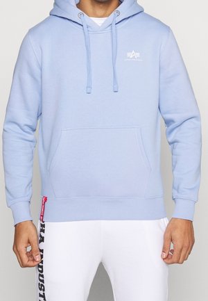 Sudadera azul claro, hecha de una tela suave, que incluye un bolsillo frontal, capucha ajustable con cordón y un logo blanco en el pecho. Puños y bajo de canalé.