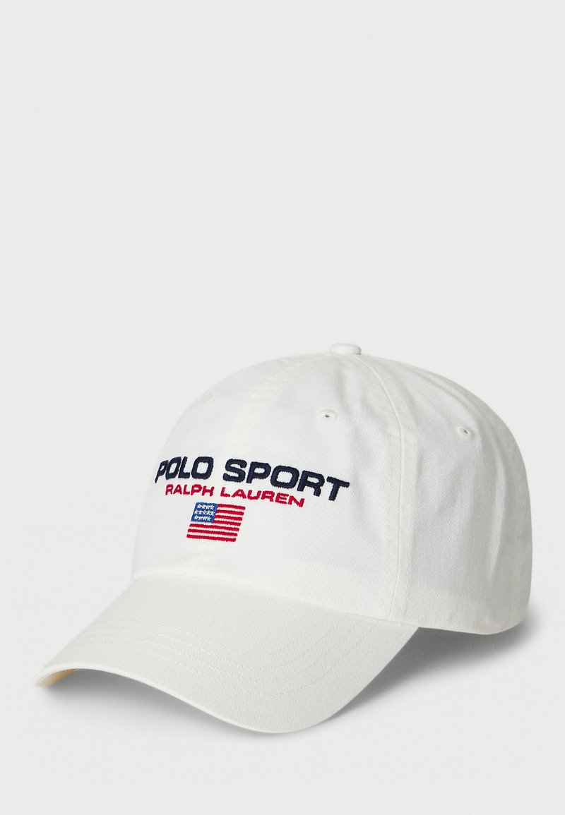Boné de beisebol branco com "POLO SPORT" e "RALPH LAUREN" em bordados azul e vermelho. Apresenta um acento da bandeira americana na frente.