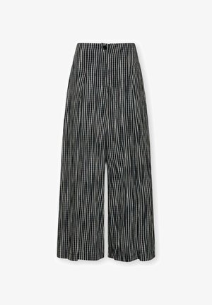 Zwarte broek met wijde pijpen, witte verticale en horizontale geruite print en een voorzijde met knopen.