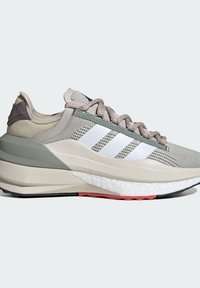 Zapatilla ligera con parte superior de malla gris, tres franjas blancas, cuello acolchado y suela texturizada con toques de color rosa y negro.