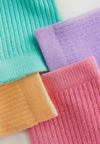 Vier Paare gerippte Socken in Pastellfarben: mintgrün, helllila, pfirsich und rosa. Jede Socke hat eine weiche, gestrickte Textur.