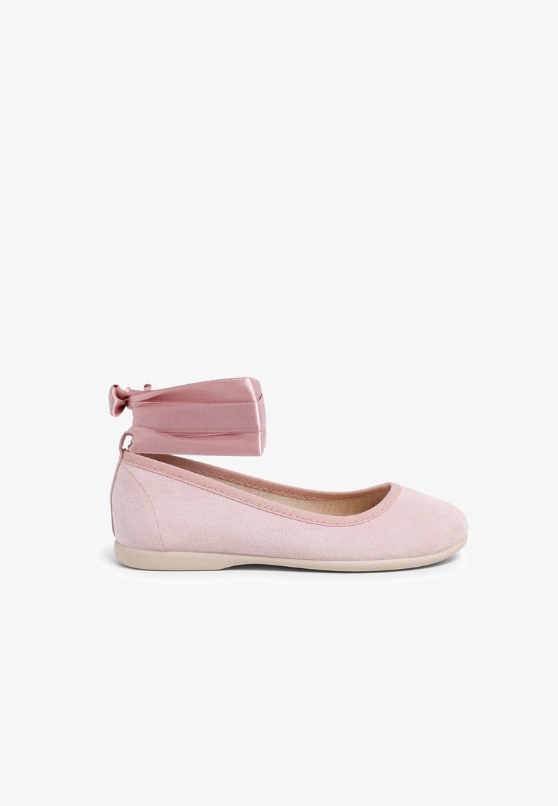 Chaussure ballerine plate rose clair avec dessus en tissu doux et large ruban en satin attaché à la cheville, noué en nœud sur fond blanc.