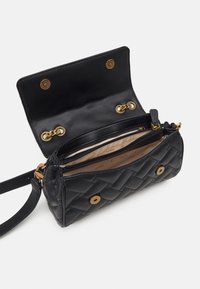 Quilted sort læder håndtaske med guldbeslag, magnetlukning og to indvendige rum; med en aftagelig rem.