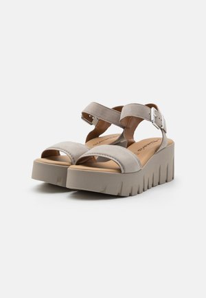 Sandalias de plataforma grises con parte superior texturizada, punta abierta y correas ajustables en el tobillo. Suela gruesa y estriada para mayor estabilidad.