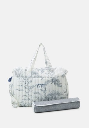 Quiltet veske i hvit med blå botanisk trykk, med to håndtak og en dekorativ pom-pom; inkluderer et rullet grått tilbehør.