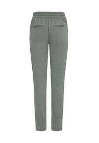 Spodnie dresowe wykonane z miękkiej szarej tkaniny o slim fit, z elastycznym paskiem w talii oraz dwiema tylnymi kieszeniami o minimalnych detalach.