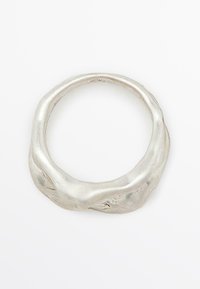 Anello in argento con una superficie irregolare e testurizzata e una forma arrotondata e organica. La finitura lucida esalta il aspetto metallico.