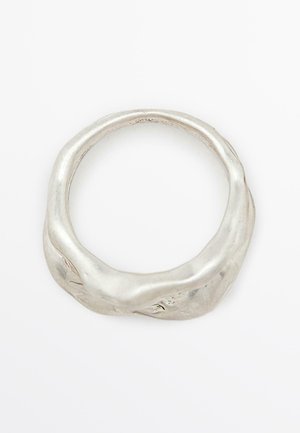 Zilveren ring met een ongelijkmatige, textuurachtige oppervlakte en een afgeronde, organische vorm. Gepolijste afwerking versterkt het metalen uiterlijk.