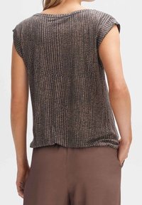 Kortärmad topp i mörkbrun, med ett texturerat stickat mönster. Lös passform med rund halsringning och rak nederkant.