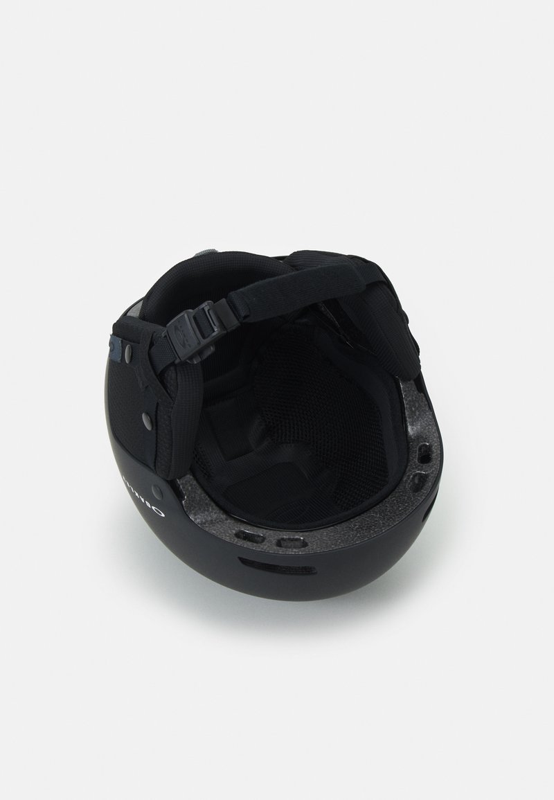 Svart hjälm med en slät yta, justerbar rem och vadderad insida. Har ventilerade sidor och en strukturerad inre foder.