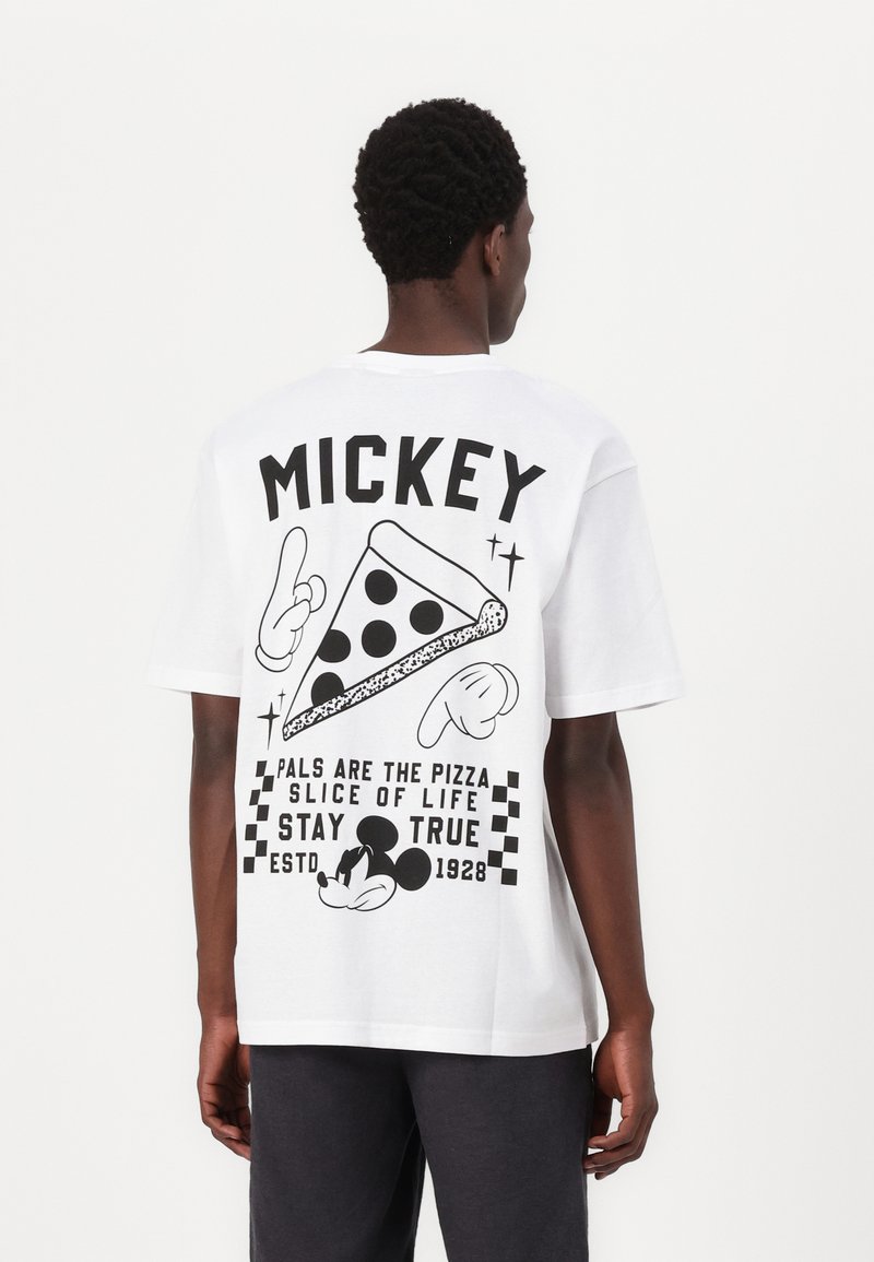 White cotton t-shirt featuring a black graphic design on the back with a pizza slice, Mickey Mouse, and text elements in bold lettering.