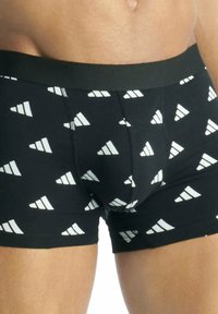 Boxer shorts neri realizzati in tessuto morbido, con un motivo triangolare astratto bianco. L'elastico in vita è nero uniforme e aderente.