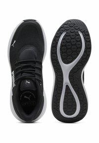 Zwarte sportieve schoenen met een bovenwerk van mesh en een gevoerde kraag. Voorzien van een witte tussenzool en een getextureerde rubberen buitenzool met een golvend patroon.