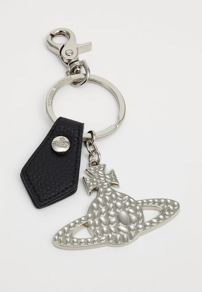 Metal keychain featuring a silver pendant shaped like a planet with dotted accents, attached to a black leather tag with a snap button.
