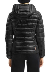 Zwarte pufferjack met een gewatteerd ontwerp, een capuchon en een oranje accentlabel aan de onderrand. Glad, glanzend materiaal met een getailleerde pasvorm.