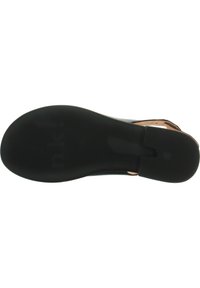 Black rubber outsole with textured surface and prominent brand logo. Designed for traction with a flat, rounded shape.