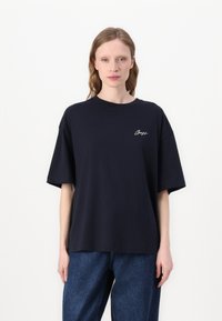 Navy blue oversized cotton t-shirt with short sleeves and a crew neckline, featuring white embroidered logo on the chest.