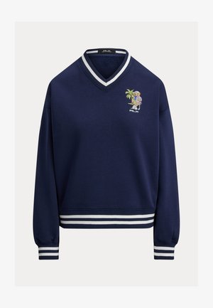 Hanorac bleumarin cu decolteu în V, manșete și tiv striate. Prezintă un design colorat brodat cu un personaj și o palmieră pe piept.