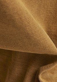 Texturerad brun tyg med ett vävt mönster, som visar en mjuk, något glansig yta och draperade veck för en lagerliknande utseende.