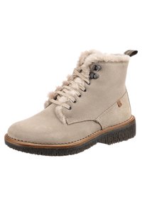 Béžová semišová kotníková bota s kožešinovou podšívkou, šněrování v přední části s kovovými kroužky a černou strukturovanou gumovou podrážkou.