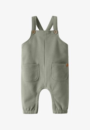 Puha zöld kisgyerek kertésznadrág állítható vállpántokkal, két első zsebbel, fa gombokkal és rugalmas szegélyekkel a bokáknál.