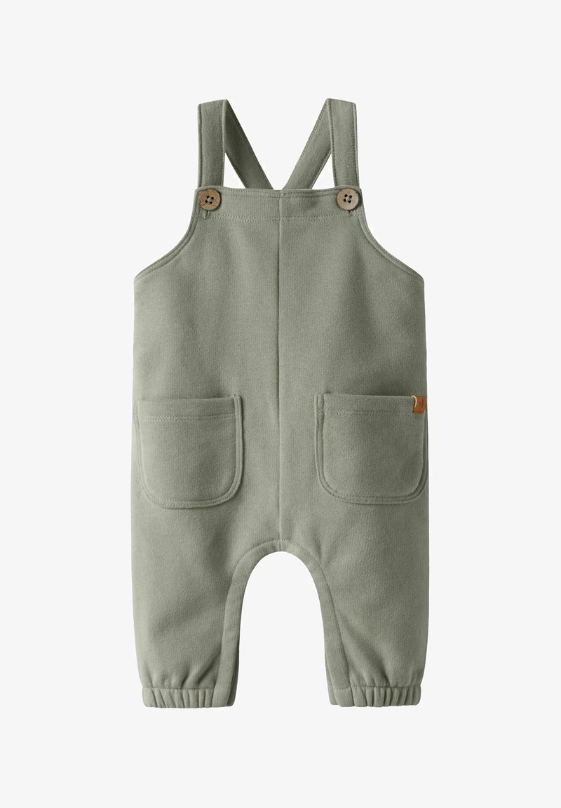 Απαλά πράσινα παιδικά ολόσωμα με ρυθμιζόμενες τιράντες στους ώμους, δύο εμπρόσθιες τσέπες, λεπτομέρειες με ξύλινα κουμπιά και ελαστικά μανσέτα στους αστραγάλους.