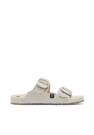 Sandalia beige de punta abierta con dos correas ajustables de malla y hebillas, suela acolchada y pequeña etiqueta oscura con logo en el lateral.