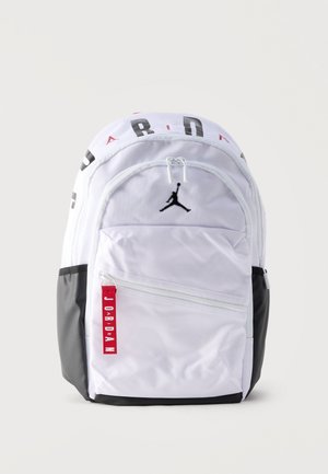 Fekete-fehér Jordan hátizsák felső cipzárral, első cipzáras zsebbel, fekete Jumpman logóval és piros "Jordan" címkével az első zsebnél.
