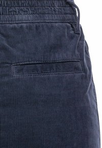 Marineblauer Cordstoff mit vertikalen Rippungen; verfügt über einen elastischen Bund und eine Gesäßtasche mit gestepptem Detail.