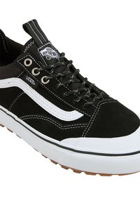 Crne zamšaste Vans tenisice s bijelom zakrivljenom prugom, crnim vezicama, metalnim rupama za vezice, podstavljenim ovratnikom i bijelim gumeni potplat s teksturiranim gumiranim donjim dijelom.